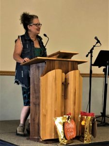 21.10.8a Beth MC M.C. Beth Rasmussen welcomes guests to a Blessed Hope event.